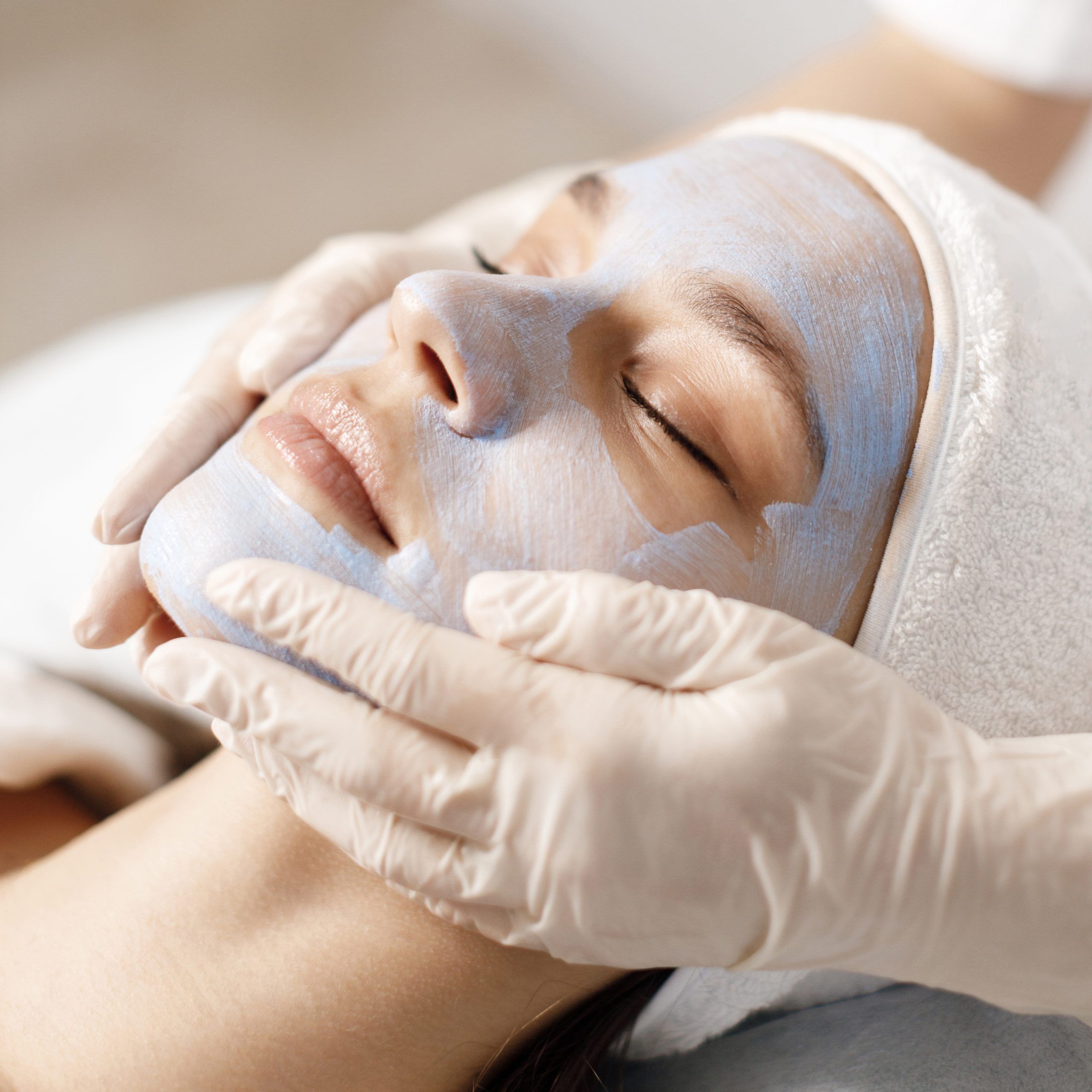 The beautiful female face. The perfect and clean skin of face on gray