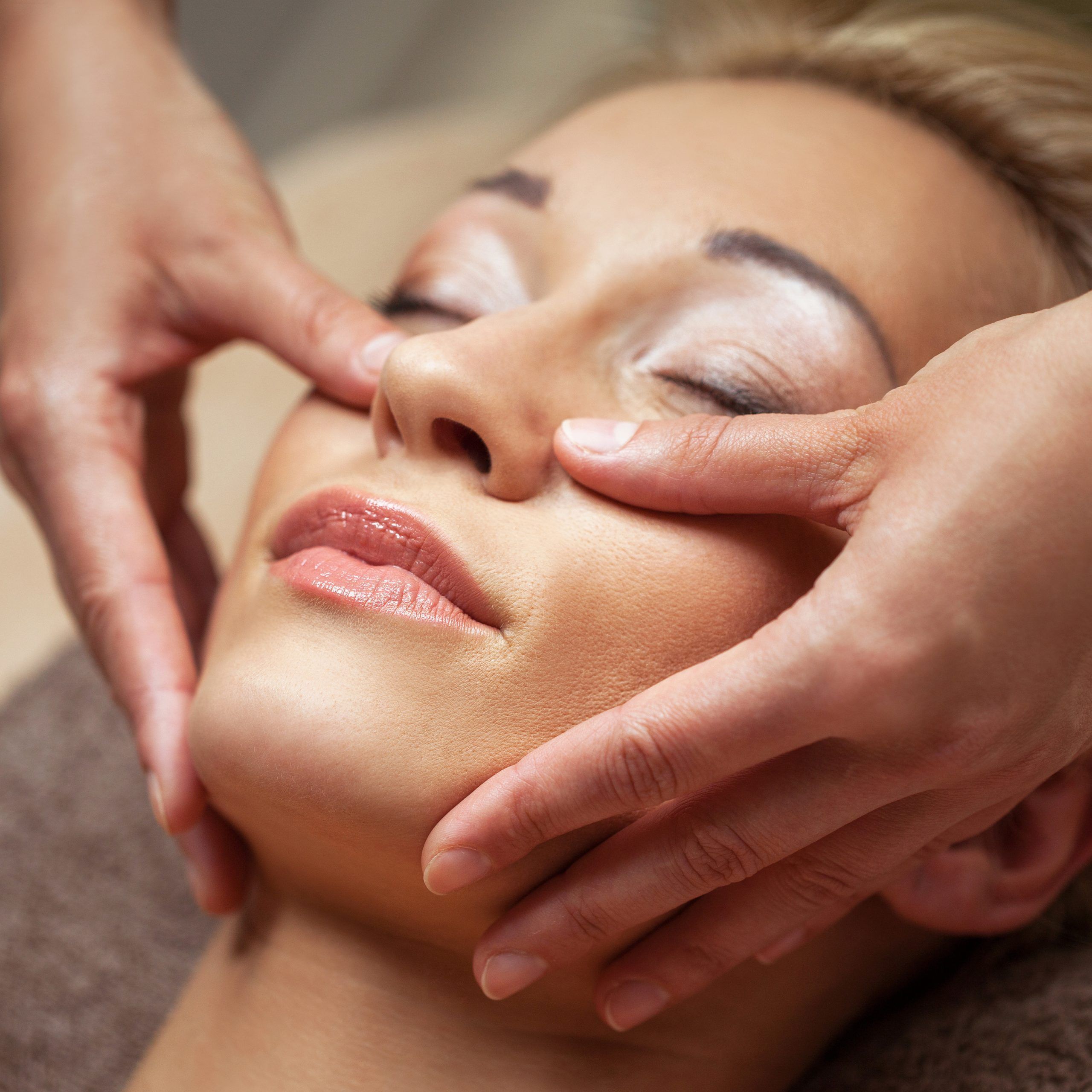 The beautiful female face. The perfect and clean skin of face on gray